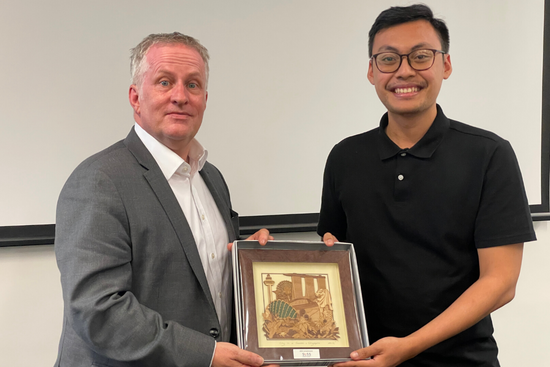 Mohamad Syafiq Bin Mohamad Zahren, SUSS Public Safety and Security student, presenting a token of appreciation to Professor Paddy Nixon, Vice Chancellor of the University of Canberra.