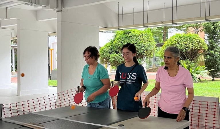 Tzu Chi seniors and SUSS student engaging in a friendly table tennis game