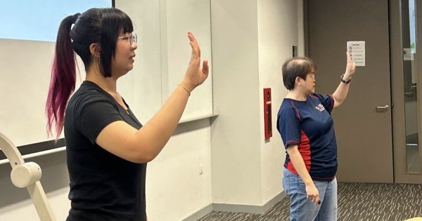 Latricia Tay (left) assisting Rosalind Foo (right) to interpret Sign Language during a session.