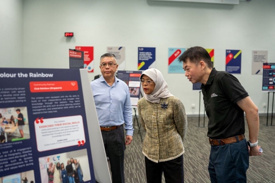 Mdm Halimah understanding more about the SUSS Service-Learning programme and its guiding principles at the exhibition