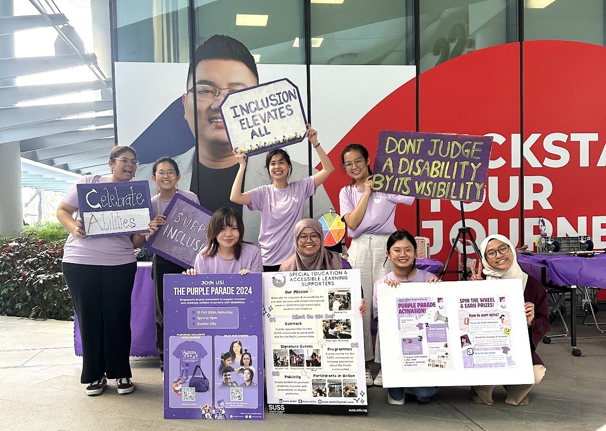 A photo of SUSS SEALS members with props made at SUSS SEALS’ Purple Parade Activation