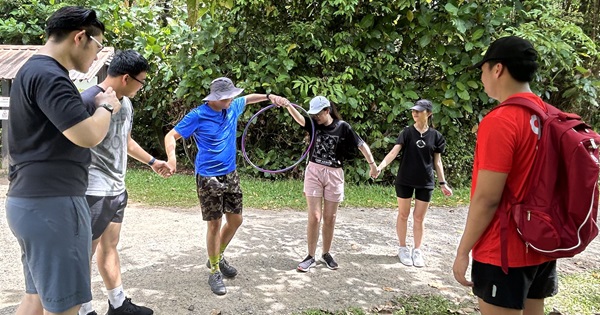 Participants realise passing hula hoops may not be as easy as they think while they attempt the Amazing race.